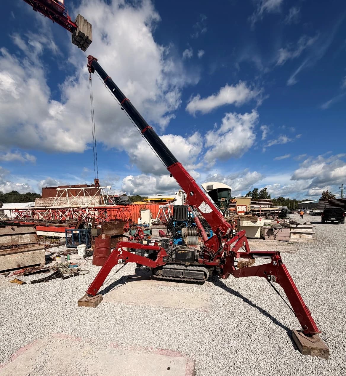 JTM Cranes red spyder crane set up on outriggers with the boom raised on a jobsite