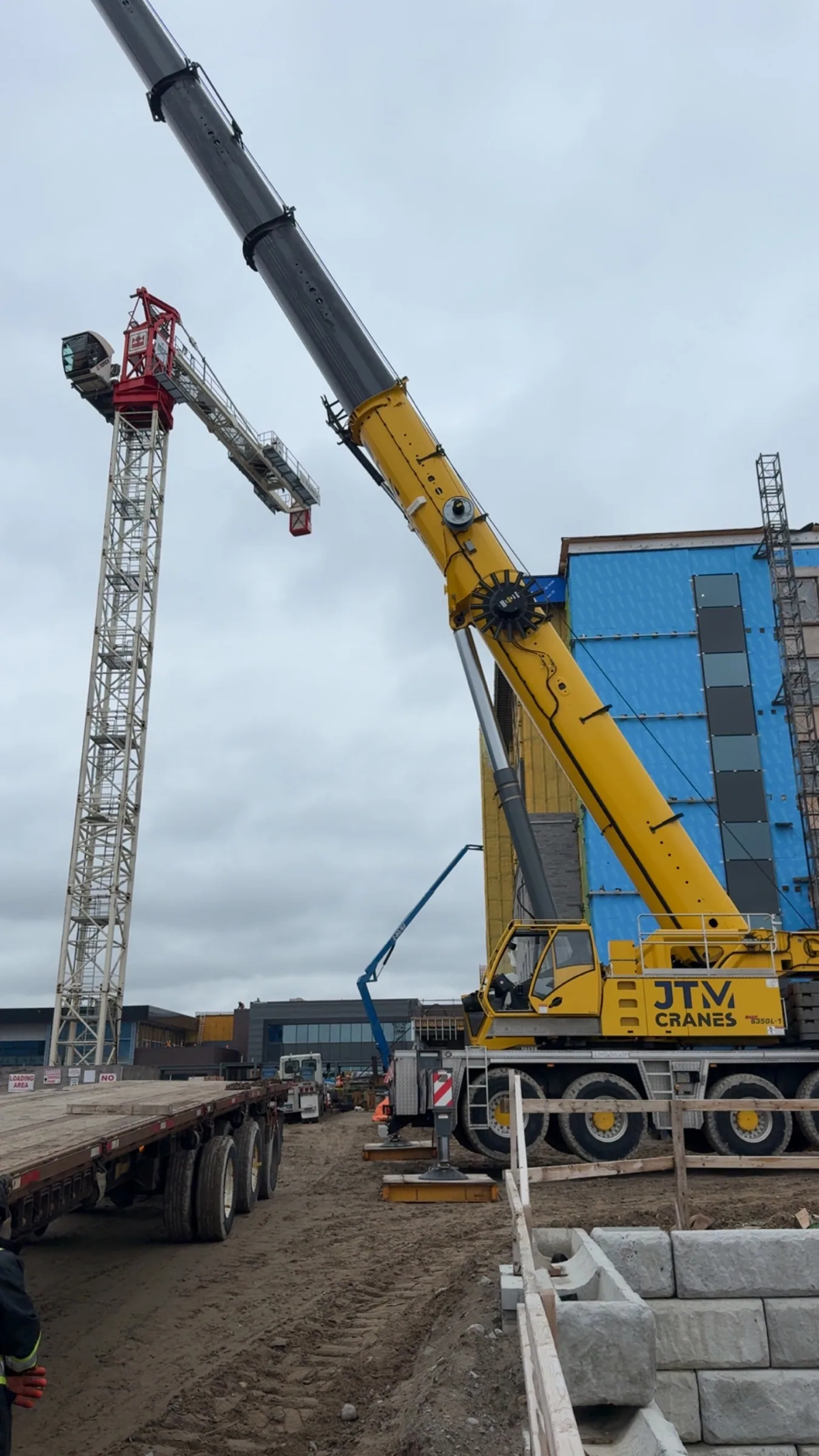 Crane setting structural steel at a commercial building frame